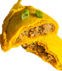 a yellow pastry with meat and greens on top